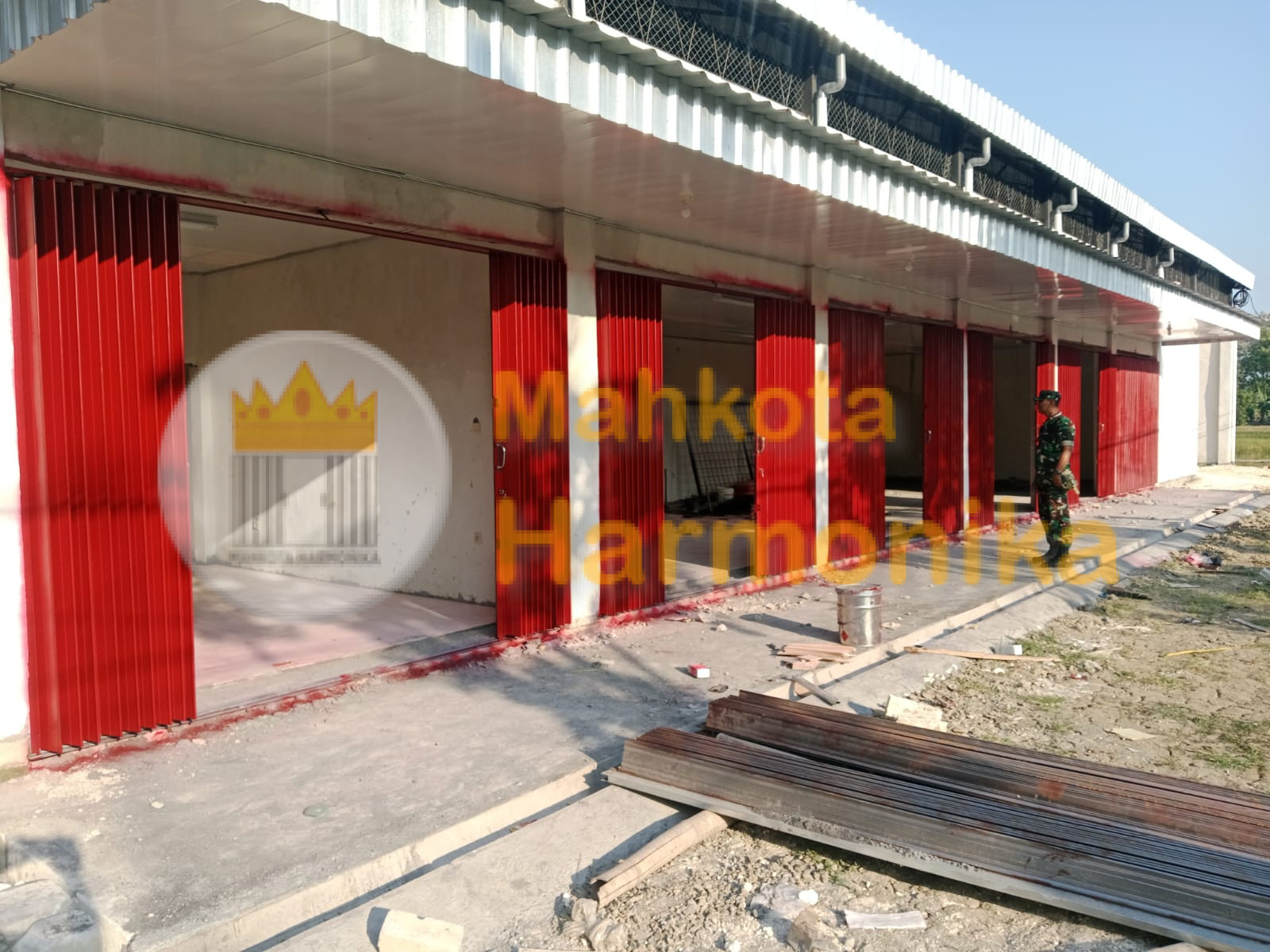Proyek pemasangan pintu harmonika merah untuk bangunan komersial